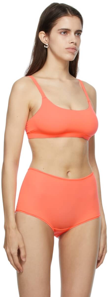 Stretch nylon jersey bra in orange. Scoop neck collar. Adjustable shoulder straps. Fully lined. Tonal hardware.